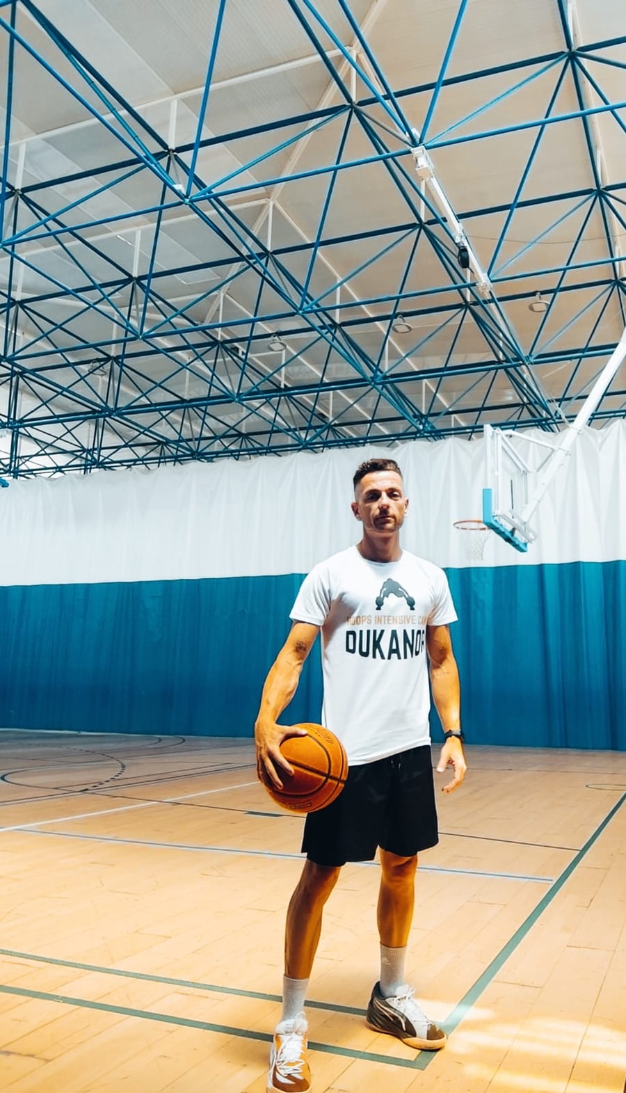 Álvaro Fuentes con camiseta Dukanor blanca y balón en la pista